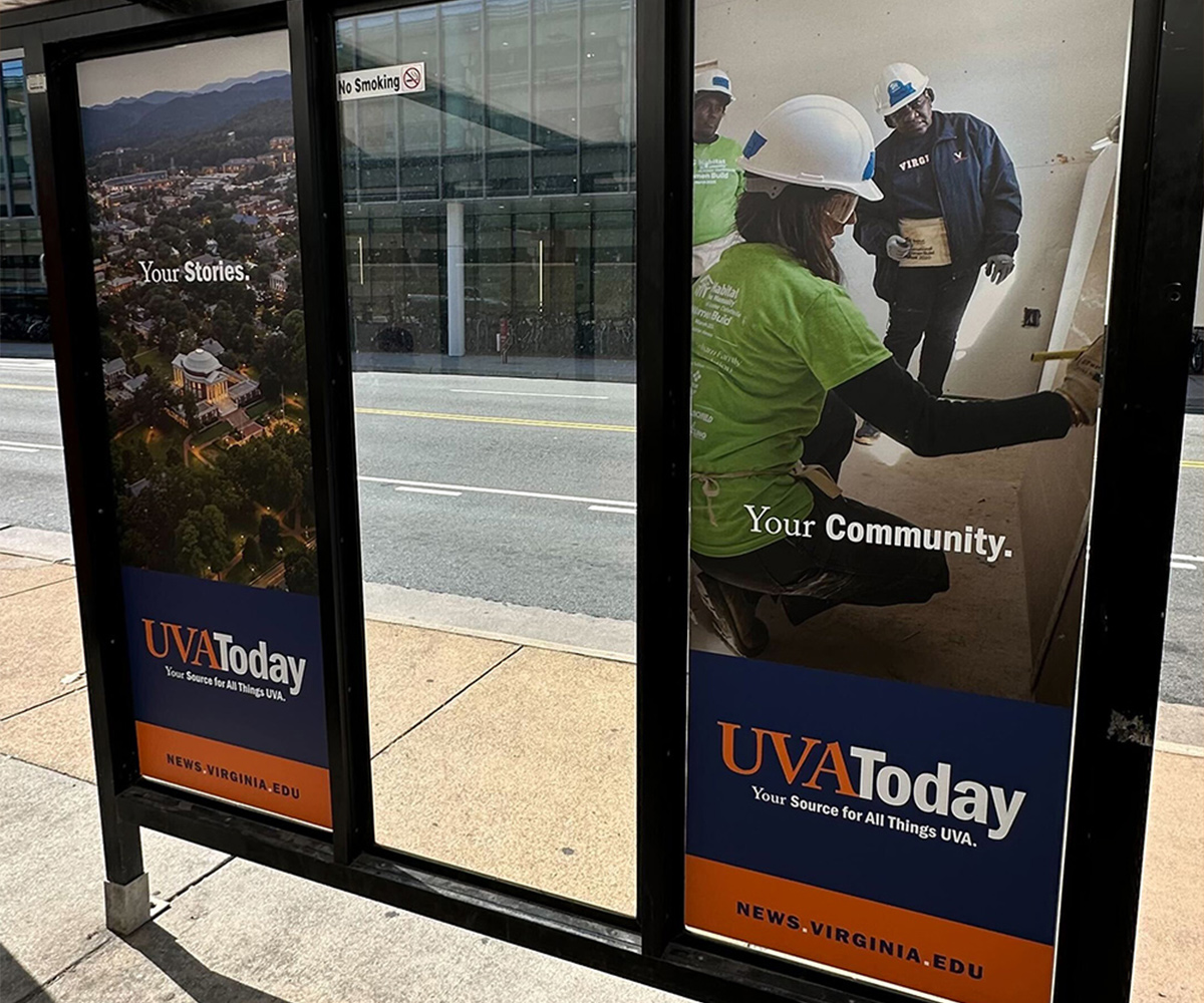 A bus shelter with UVA Today ads